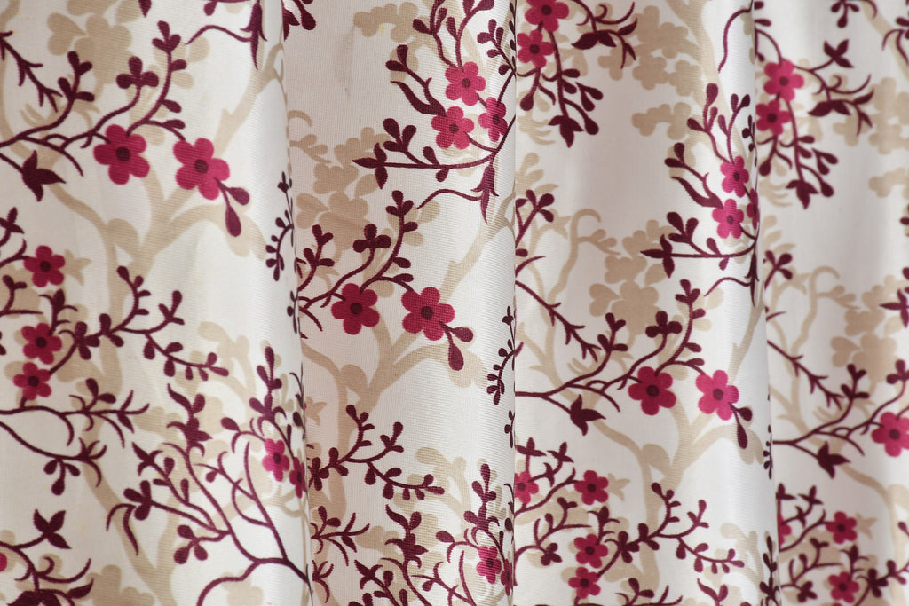 Surbhi SILMILI print curtains in wine color with floral patterns, designed by The Digital Kart, hanging on a window.