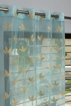 Aqua net curtains from The Digital Kart hanging in a window, showcasing lightweight, sheer fabric for privacy and sunlight diffusion.